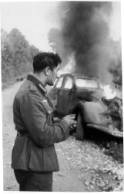 Soldat Allemand blessé devant sa Peugeot 402 qui brûle -photo ECPA